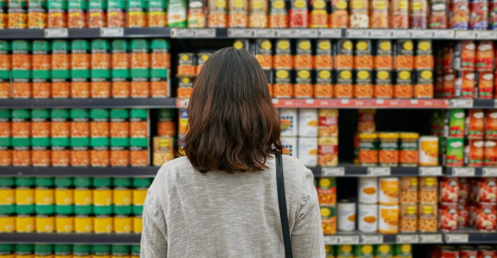 A woman standing in front of a supermarket shelf
