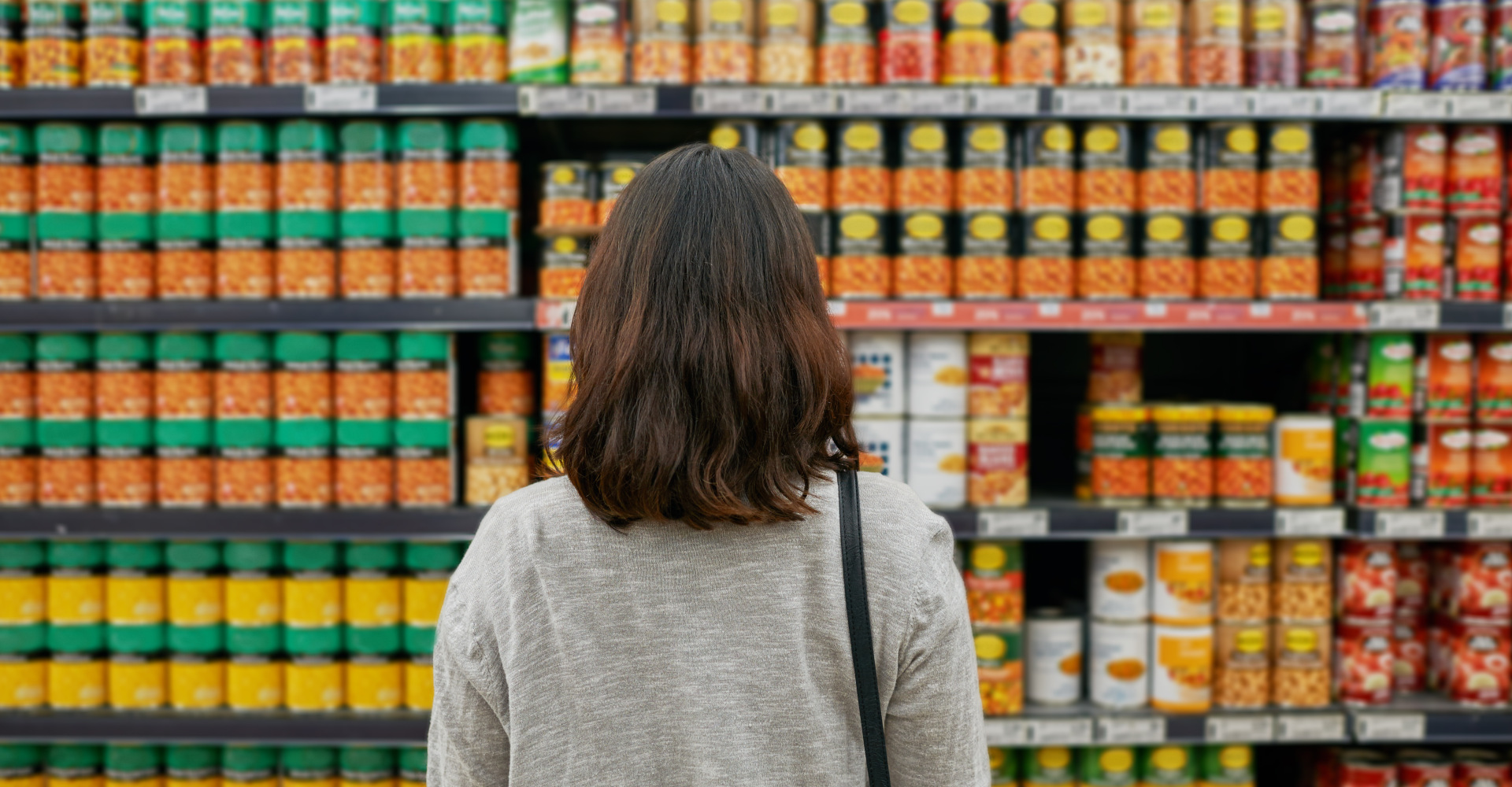 A woman standing in front of a supermarket shelf