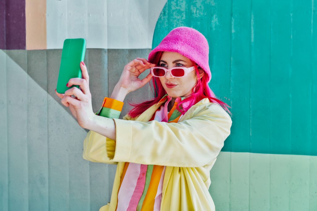 A cool woman with colorful clothing taking a selfie