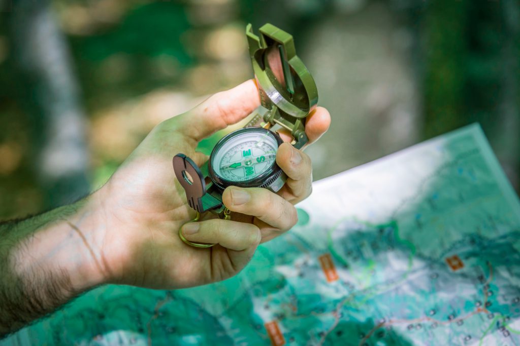 A man holding a compass and a map
